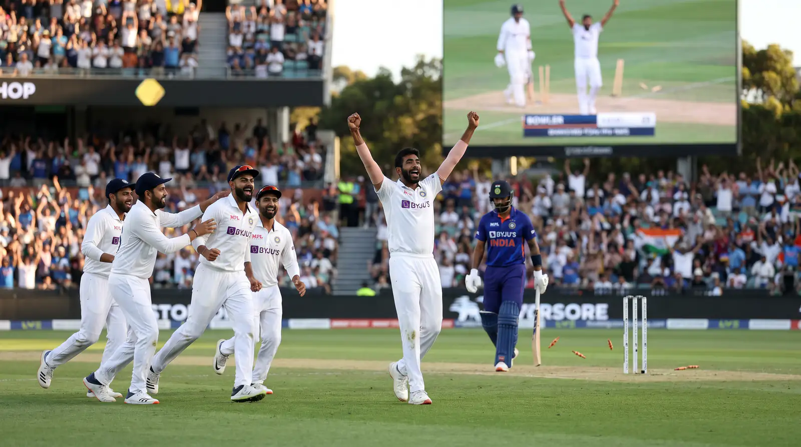Cricket bowler celebrating taking a wicket with arms raised on the pitch