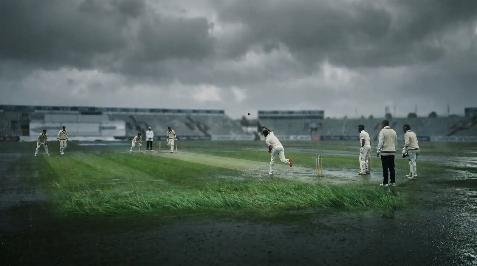 Overcast conditions at a cricket ground with green-tinged pitch for seam bowling